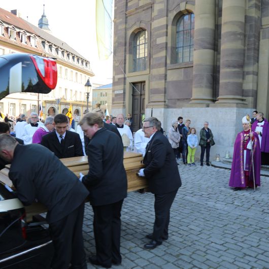 Bischof Dr. Jung wartet am Leichenwagen vor der Seminarkirche, bis der Sarg mit dem Leichnam von Bischof em. Dr. Paul-Werner Scheele verstaut ist.
